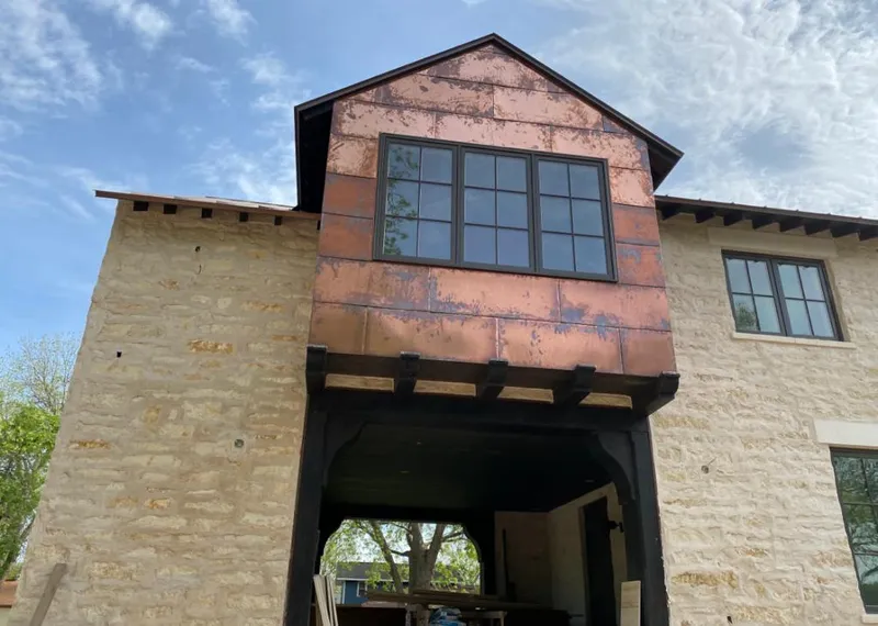 Copper metal panel facade on a stone building for Skylight Installation in Peppermill Village