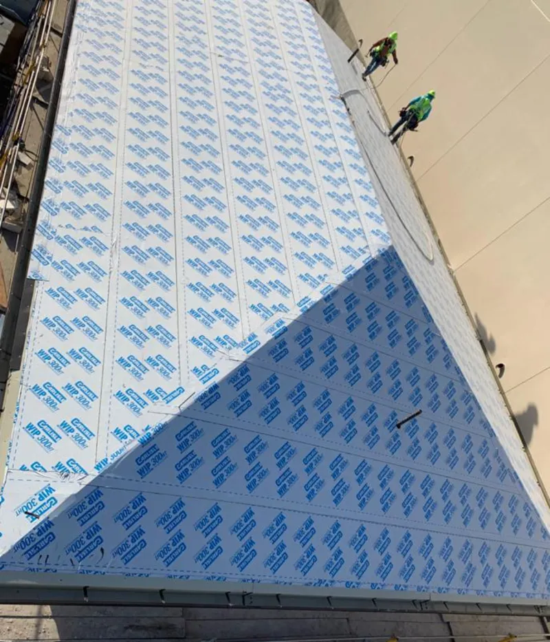 Professional roofers installing underlayment on a metal roof in Peppermill Village